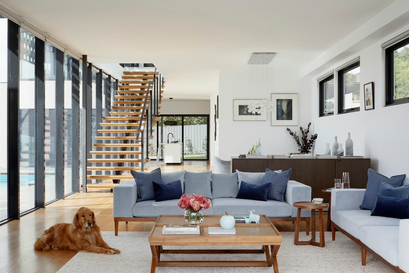 A living room with a staircase and a dog on the rug